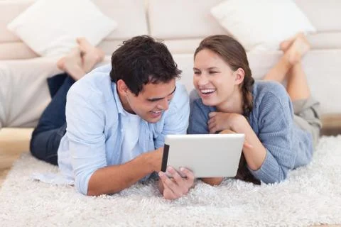 Delighted couple using a tablet computer Stockfoto's
