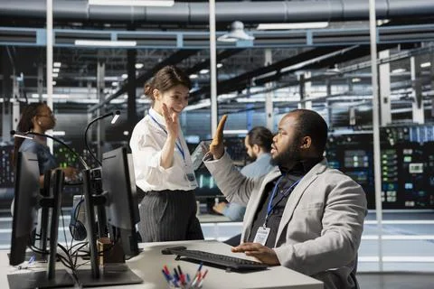 Delighted data center colleagues doing high five, celebrating AI implementation Stockfoto's