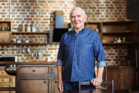 Delighted elderly man standing in the kitchen Stock Photos