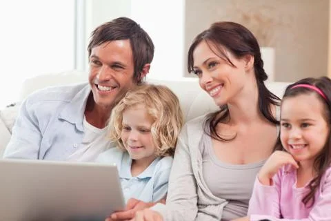 Delighted family using a notebook Stock Photos