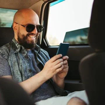 Delighted man using mobile app traveling by car Stock Photos