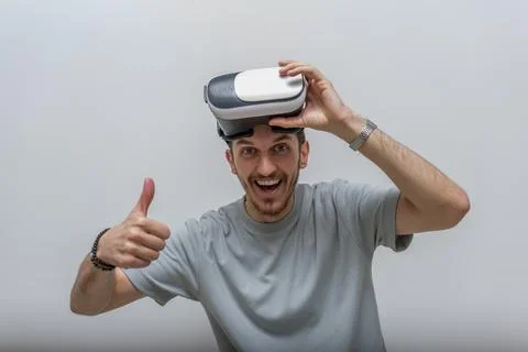 A delighted man wearing VR glasses is immersed in Foto stock