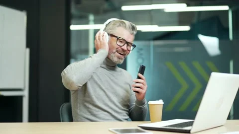 Delighted mature gray haired bearded man in glasses relaxing listening to music  Stock Footage 232575752