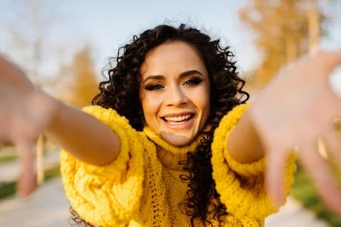 Delighted to meet the smiling broadly pulls her hands towards the girl with dark Stock Photos