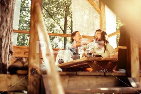 Delighted nice man being fed by his wife Stock Photos