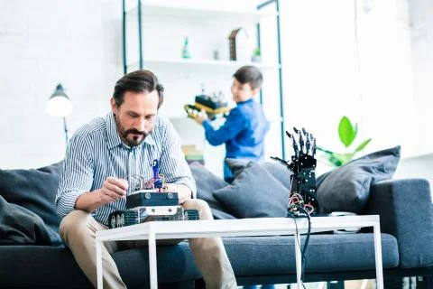 Delighted smart man constructing a robotic device Foto stock