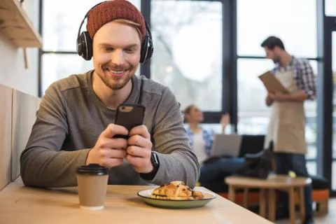 Delighted young man using his gadget Stock Photos