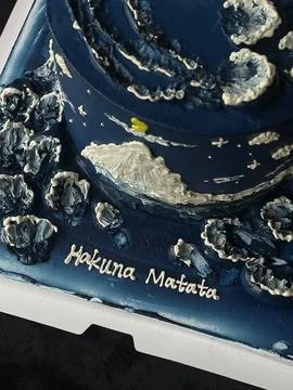 Delightful cake featuring a blue theme with mountain and flower designs for.. Stock Photos