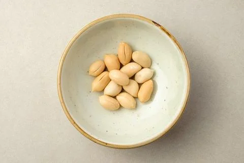 Delightful collection of shelled peanuts in a rustic ceramic bowl Stock Photos