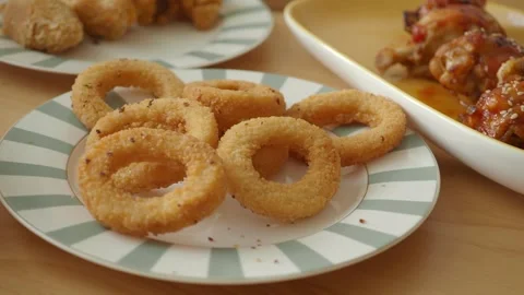 Delightful crispy onion rings served with savory treats Stock Footage 339050591