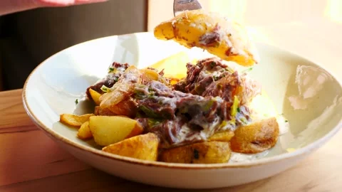 A delightful dish of cooked potatoes and succulent meat, creating a tempting Stock Footage 311874038