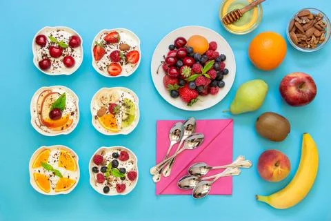 Delightful spread of assorted desserts and fruits arranged on a vibrant blue Stock Photos