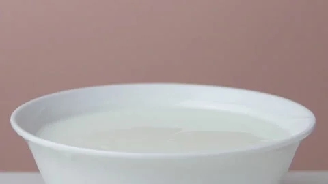 Delisious cherries are falling into a plate of sour cream Stock Footage 135578390