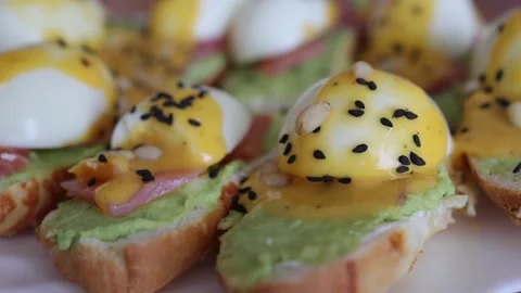 Delitious toast with salmon, boiled egg and guacamone on a white plat sprinkled Vídeos de archivo 218442755