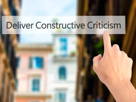 Deliver Constructive Criticism - Hand pressing a button on blurred background Stock Photos