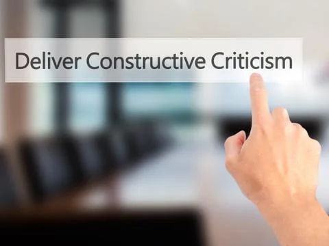 Deliver Constructive Criticism - Hand pressing a button on blurred background Stock Photos