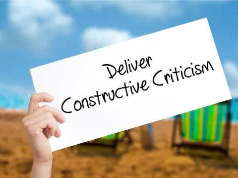 Deliver Constructive Criticism Sign on white paper. Man Hand Holding Paper wi Stock Photos