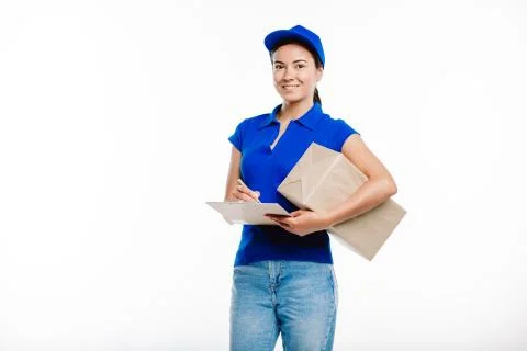 Deliverer with a notepad with a big box by her side. Stock Photos
