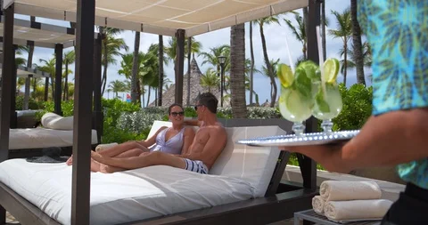 Delivering Drinks to Couple Poolside at Tropical Resort Pool Stock Footage 103220563