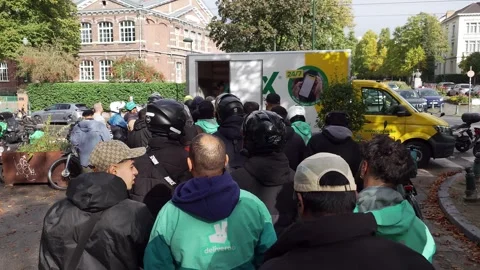 Deliveroo riders queueing in the city for free company goodies, kit items Stock Footage 255588136