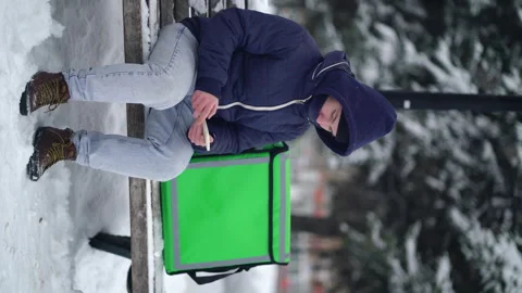 Delivery boy with an insulated backpack looking for the client's address in the Stock Footage 146140239