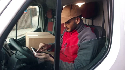 Delivery Boy Sitting In The Van Looking Up Address Using A Tablet Parcel Stock Footage 155720689