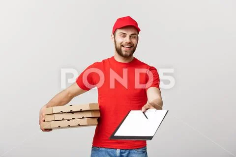 Delivery Concept: Young handsome delivery man with pizza boxes giving you a Stock Photos