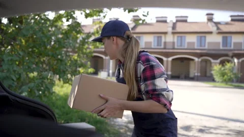 Delivery courier getting cardboard boxes from car Stock Footage 194787930