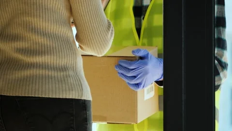 Delivery courier in protective gloves handing cardboard box to female custo.. Stock Footage 334855860