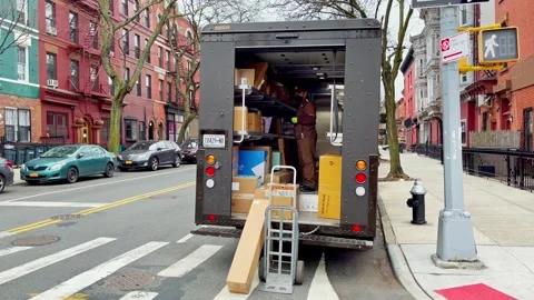 Delivery courier standing inside open transport truck filled with cargo boxes Stock Footage 335203368