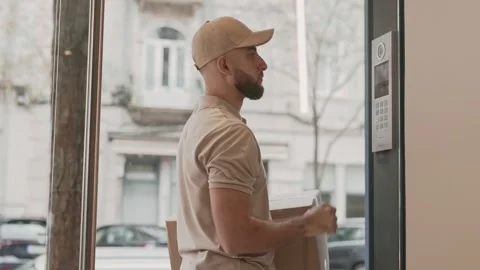 Delivery Courier Using Intercom To Enter Apartment Building Stock Footage 276378553