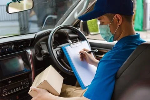Delivery courier young man driver inside the van car with parcel post boxes c Stockfoto's