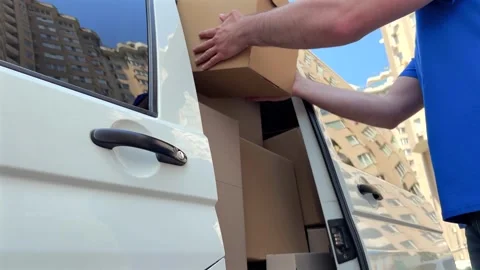 Delivery driver approaches white van and opens the door to retrieve packages Vídeos de archivo 337612726