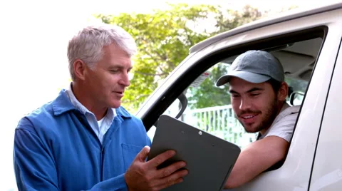 Delivery driver checking his list on clipboard with client Stock Footage 40408365
