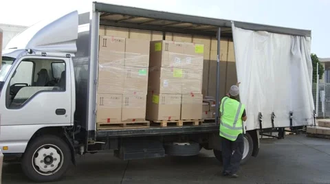 Delivery driver closing curtain on his white truck full of boxes Stock Footage