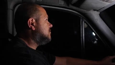 Delivery driver focused while driving van at night Stock Footage 332423886