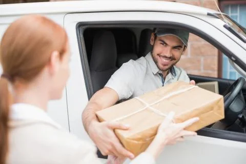 Delivery driver handing parcel to customer in his van Stock Photos