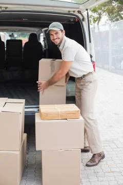 Delivery driver loading his van with boxes Stock Photos