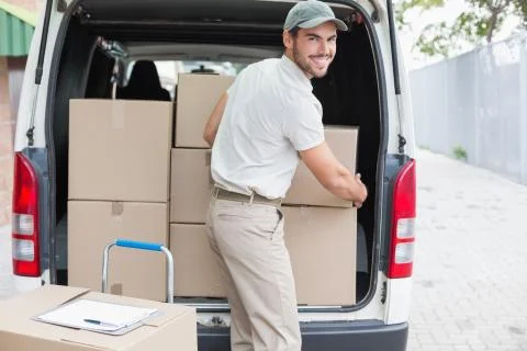 Delivery driver loading his van with boxes Stock Photos