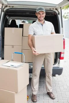 Delivery driver loading his van with boxes Stock Photos