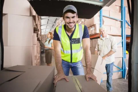 Delivery driver loading his van with boxes Stock Photos