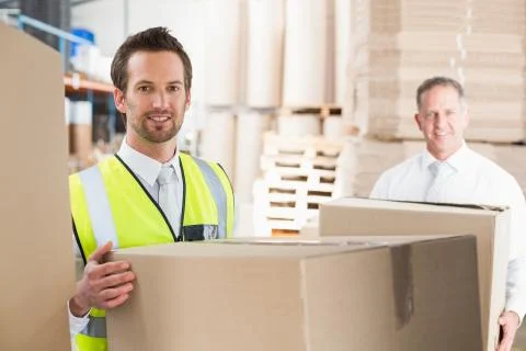 Delivery driver loading his van with boxes Stock Photos