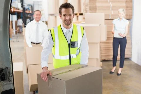 Delivery driver loading his van with boxes Stock Photos