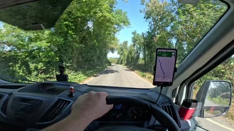 A Delivery Driver is Navigating a Van Through the Scenic Country Roads of Stock Footage 263692436