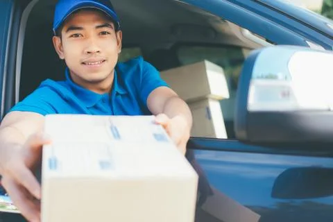 Delivery driver offering parcel to customer. Stock Photos