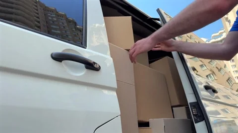 Delivery driver opens van door in vibrant cityscape to prepare for delivery Vídeo Stock 336525789