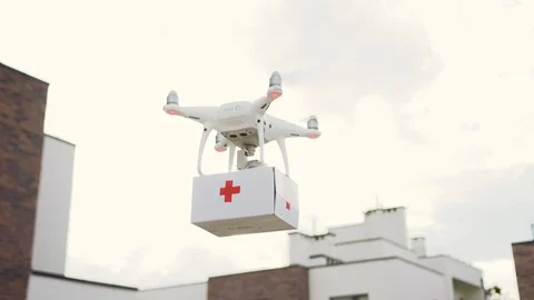 Delivery drone carrying a first-aid kit in air. White quadrocopter delivering Stock Footage 113799704