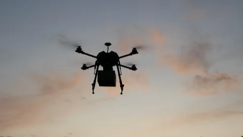 A Delivery Drone Transport Package, Sunset Silhouette Stock Footage 120210530