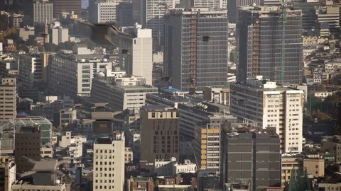 Delivery drones flying busily over high-rise buildings in a metropolitan area Stock Footage