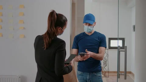Delivery guy with protection face mask holding POS terminal delivering takeaway Stock Footage 155445461